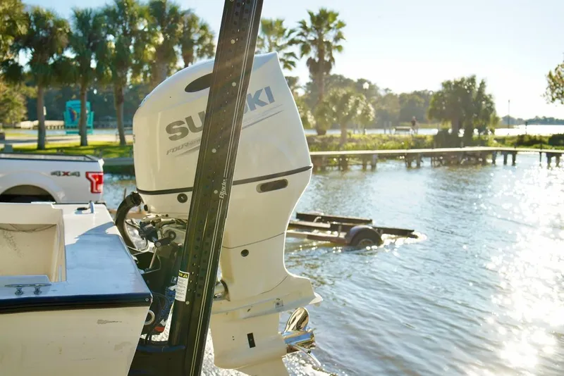 Slide: The Image of 1970 Aquasport 222 Flatback with Suzuki outboard motor near a scenic waterfront. - 25