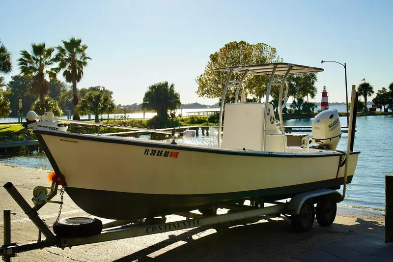 Slide: The Image of 1970 Aquasport 222 Flatback boat on trailer by scenic waterfront with palm trees. - 4