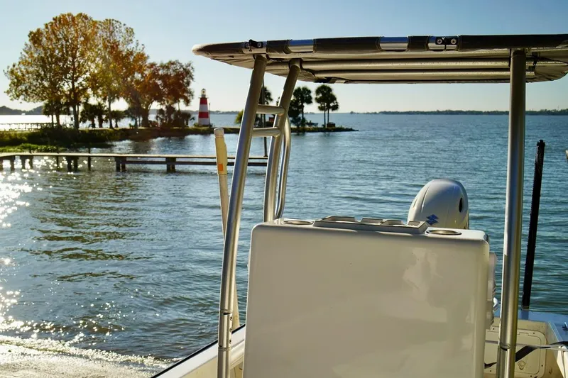 Slide: The Image of 1970 Aquasport 222 Flatback boat on serene lake with lighthouse in background. - 21