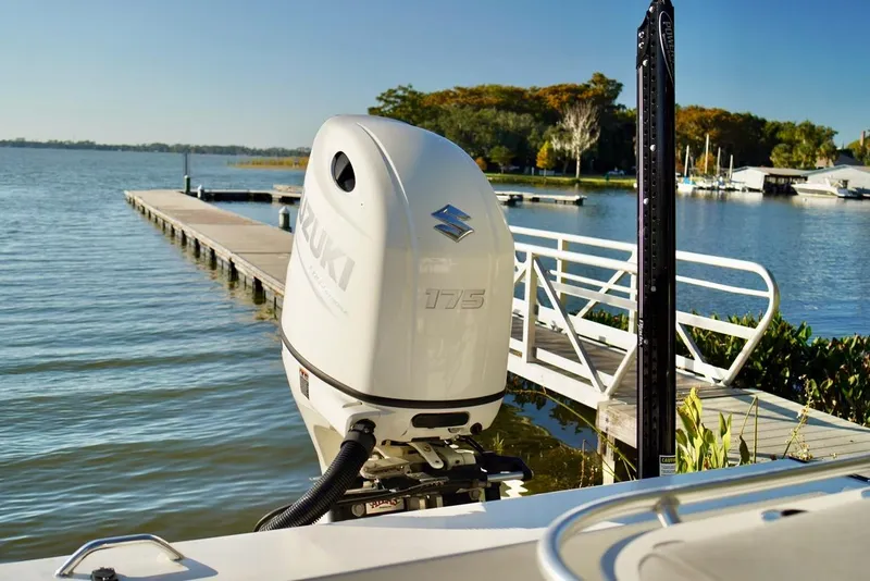 Slide: The Image of 1970 Aquasport 222 Flatback with Suzuki 175 outboard motor by a scenic dock. - 24