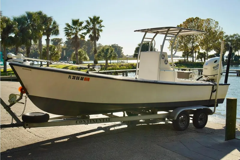 Slide: The Image of 1970 Aquasport 222 Flatback boat on trailer by waterfront with palm trees. - 3