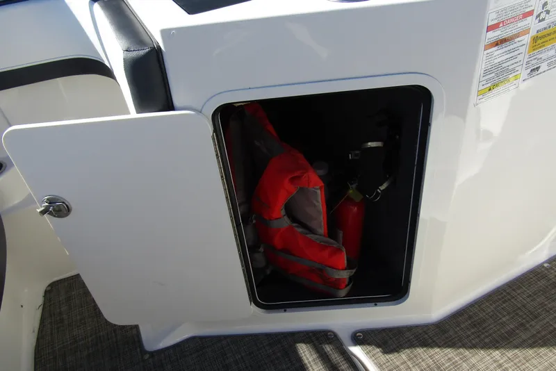 Slide: The Image of Open storage compartment on 2018 Sea Ray SPX 190 Outboard with life jacket and fire extinguisher. - 19