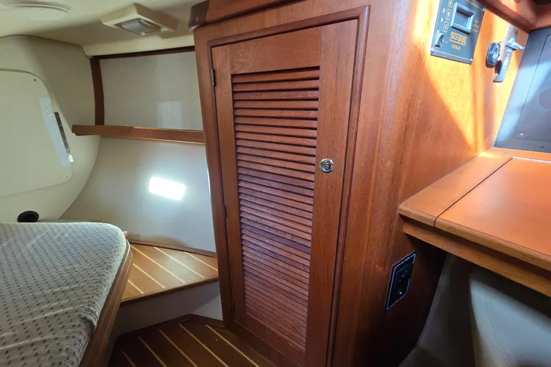 Slide: The Image of 2006 Island Packet 370 interior with wooden cabinetry and cozy sleeping area. - 33