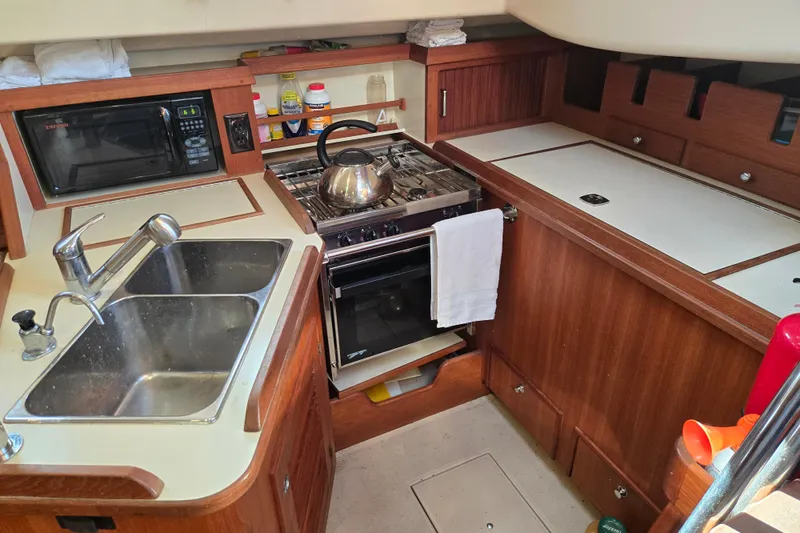 Slide: The Image of Galley kitchen in 2006 Island Packet 370 sailboat with sink, stove, and microwave. - 35
