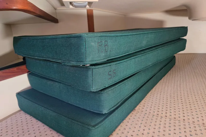 Slide: The Image of Stacked green cushions inside a 2006 Island Packet 370 sailboat cabin. - 40