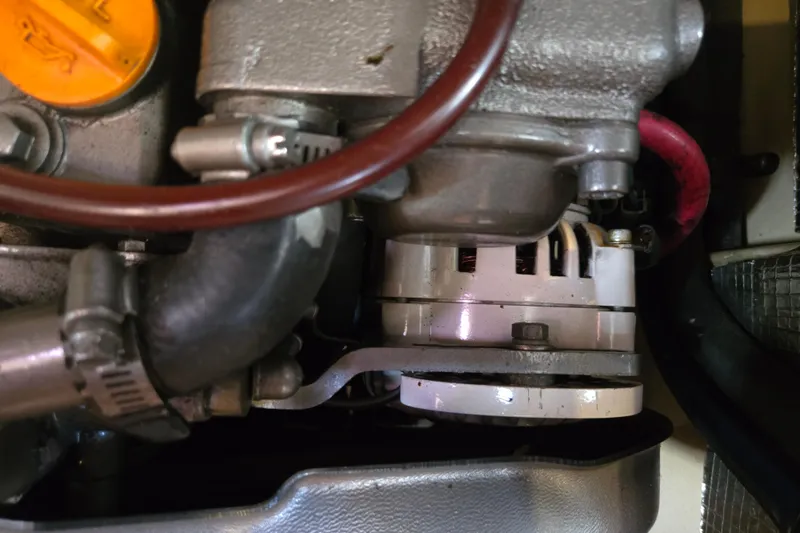 Slide: The Image of Engine components of a 2006 Island Packet 370 sailboat, featuring hoses and metal parts. - 47