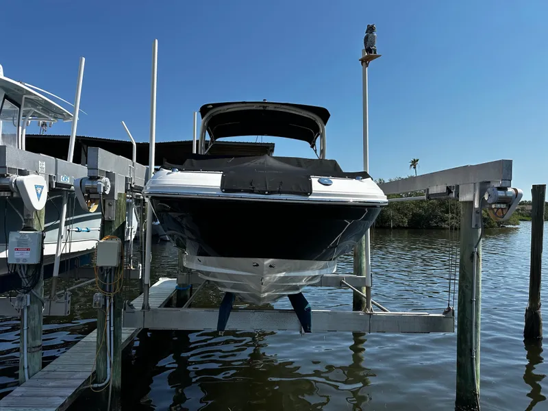Slide: The Image of 2023 Sea Ray SDX 250 Outboard on boat lift by water. - 2