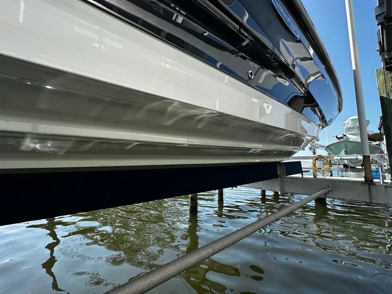 Slide: The Image of Sea Ray SDX 250 Outboard 2023 on a boat lift by the water. - 5