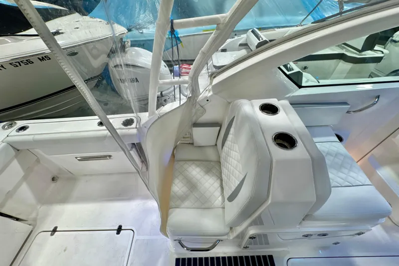Slide: The Image of 2024 Pursuit DC 266 Dual Console boat interior with white seating and cup holders. - 13
