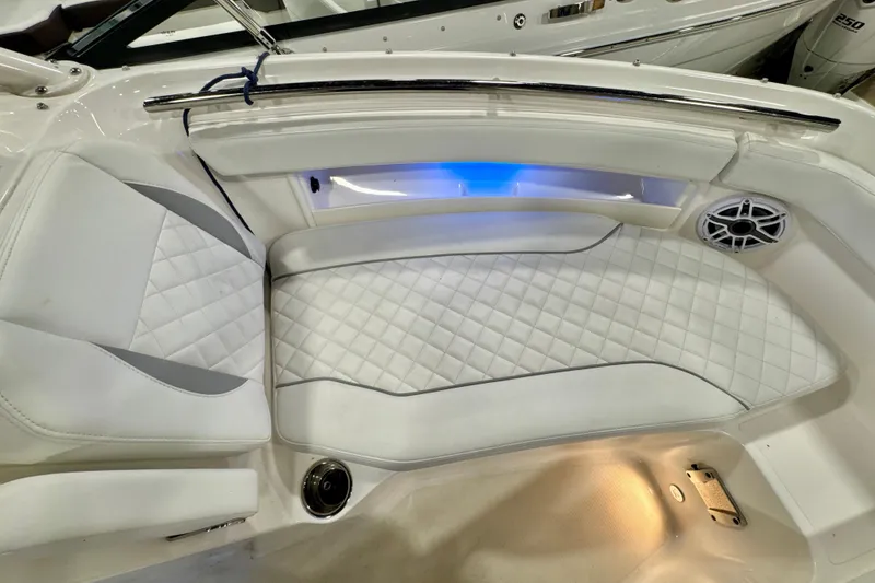 Slide: The Image of 2024 Pursuit DC 266 Dual Console boat interior with white quilted seating and ambient lighting. - 26