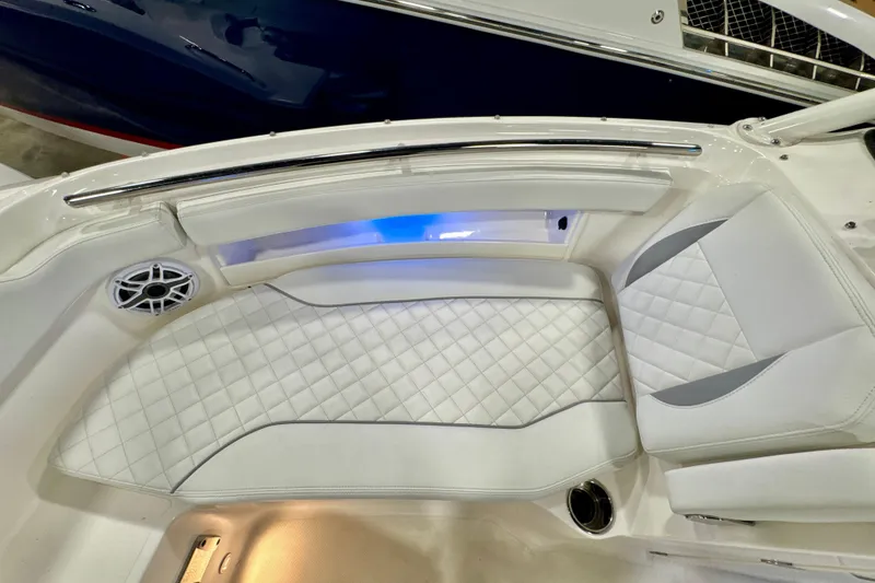 Slide: The Image of 2024 Pursuit DC 266 Dual Console boat interior with white quilted seating and blue accent lighting. - 27