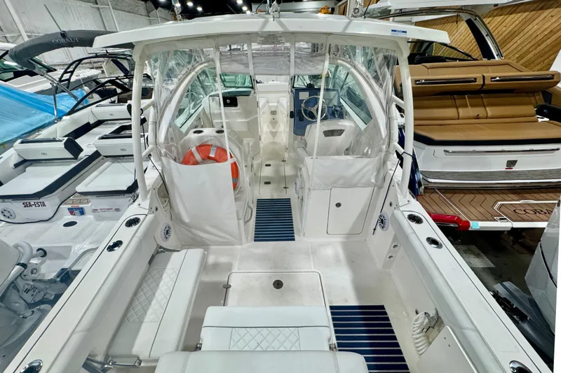 Slide: The Image of 2024 Pursuit DC 266 Dual Console boat interior with seating and helm, showcased indoors. - 4