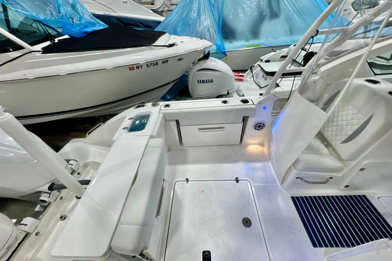 Slide: The Image of 2024 Pursuit DC 266 Dual Console boat interior with Yamaha engine, featuring white seating and storage. - 6