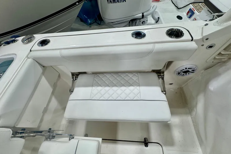 Slide: The Image of 2024 Pursuit DC 266 Dual Console boat interior with white seating and cup holders. - 7