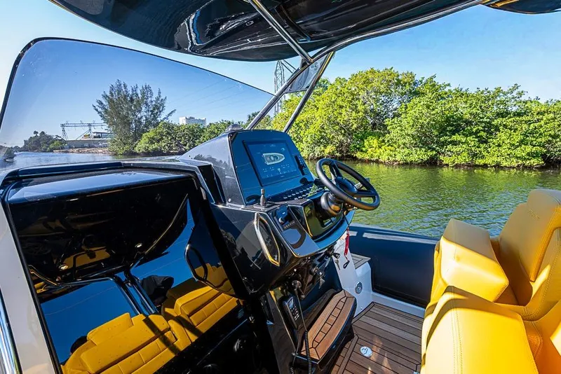 Slide: The Image of 2025 SACS Strider 11 boat cockpit with modern controls and yellow seating on a sunny day. - 11