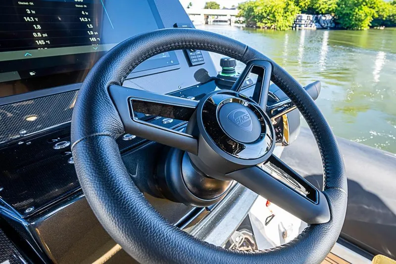 Slide: The Image of Steering wheel of 2025 SACS Strider 11 boat, with dashboard and water view. - 15