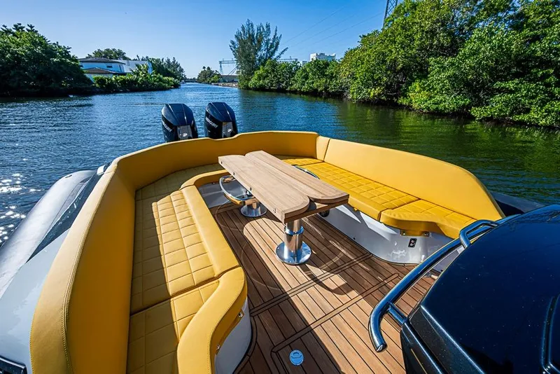 Slide: The Image of Luxurious 2025 SACS Strider 11 boat with yellow seating and wooden deck on a scenic waterway. - 24
