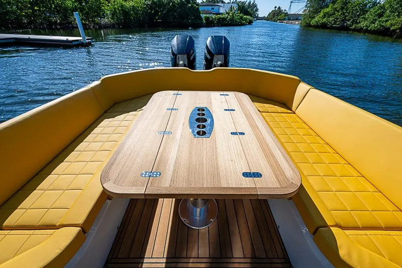 Slide: The Image of Luxurious 2025 SACS Strider 11 boat with yellow seating and wooden table on a serene waterway. - 26