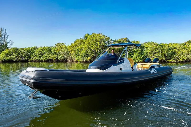 Slide: The Image of 2025 SACS Strider 11 boat cruising on a sunny day near lush greenery. - 4