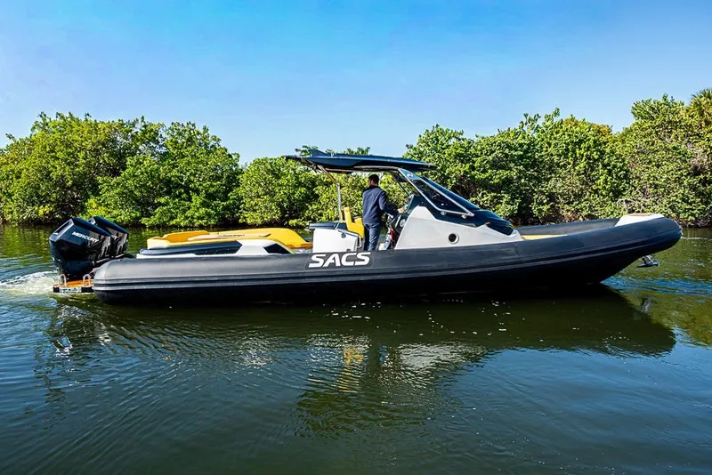 Slide: The Image of 2025 SACS Strider 11 boat cruising on a calm river with lush greenery. - 7