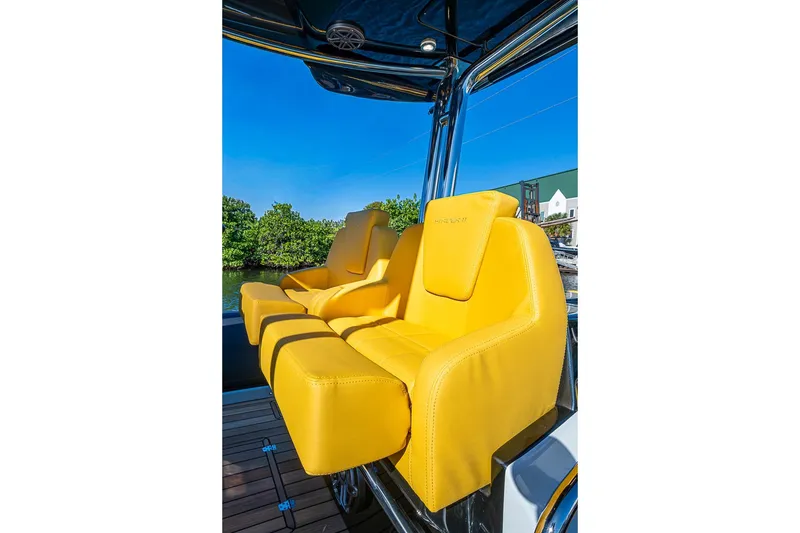 Slide: The Image of Yellow seats on 2025 SACS Strider 11 boat, under clear blue sky. - 12
