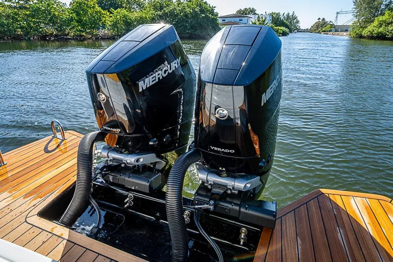 Slide: The Image of Twin Mercury Verado engines on 2025 SACS Strider 11 boat, docked on a sunny day. - 40