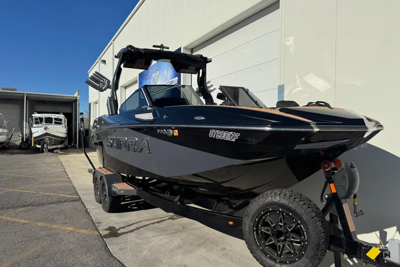 Slide: The Image of 2024 Supra SL 575 boat on trailer outside a marine dealership. - 3