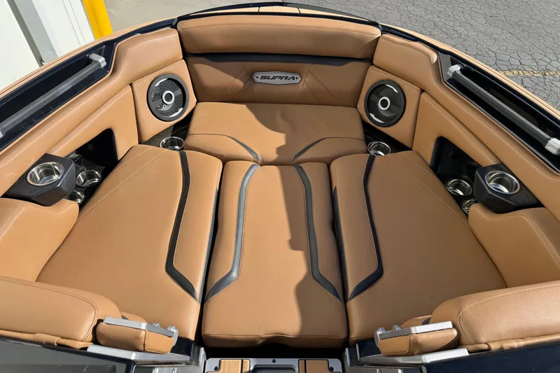 Slide: The Image of 2024 Supra SL 575 boat interior with tan leather seating and built-in speakers. - 5