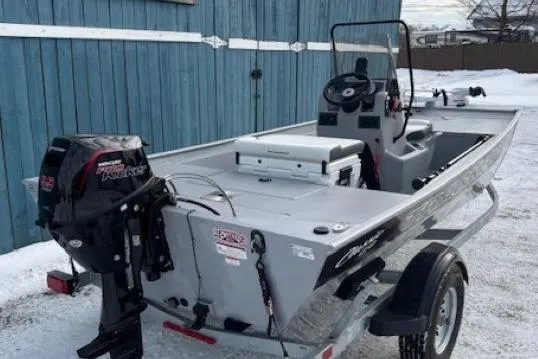 Slide: The Image of 2026 Tracker Bass Tracker Classic CC boat on trailer, parked near blue building. - 2