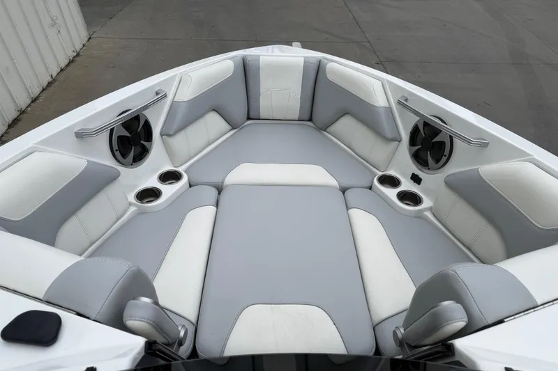 Slide: The Image of 2020 Malibu Wakesetter 25 LSV boat interior with gray and white seating, cup holders, and speakers. - 13