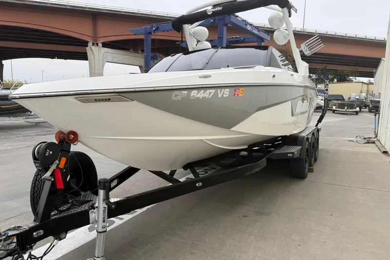 Slide: The Image of 2020 Malibu Wakesetter 25 LSV boat on trailer, parked under a bridge. - 3