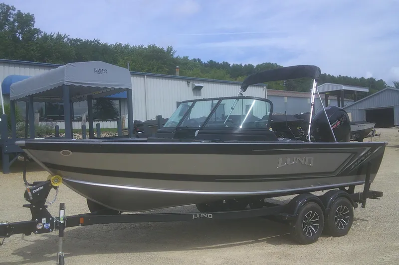 Slide: The Image of 2026 Lund 1875 Impact XS Sport boat on trailer, parked outdoors. - 5