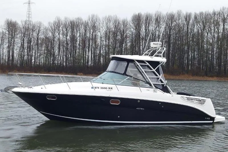 Slide: The Image of 2009 Sea Ray 290 Amberjack boat on a calm river with forested background. - 13