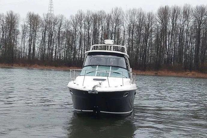 Slide: The Image of 2009 Sea Ray 290 Amberjack boat on a calm river with trees in the background. - 15