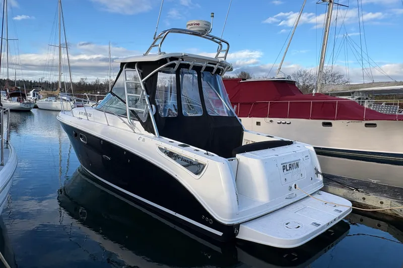 Slide: The Image of 2009 Sea Ray 290 Amberjack boat docked in a marina, surrounded by other vessels. - 27