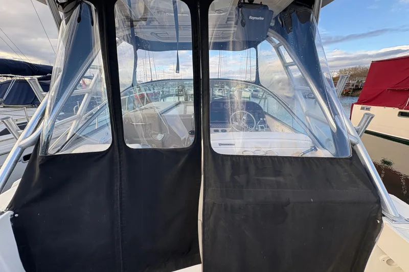 Slide: The Image of 2009 Sea Ray 290 Amberjack boat cockpit with clear enclosure and visible steering wheel. - 30