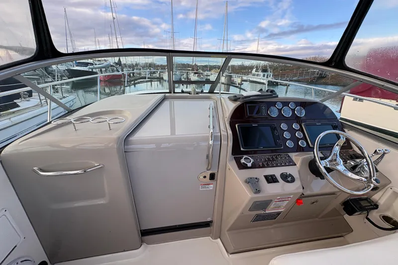Slide: The Image of 2009 Sea Ray 290 Amberjack helm with modern controls and marina view. - 42