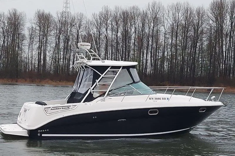 Slide: The Image of 2009 Sea Ray 290 Amberjack boat on a calm river with trees in the background. - 6