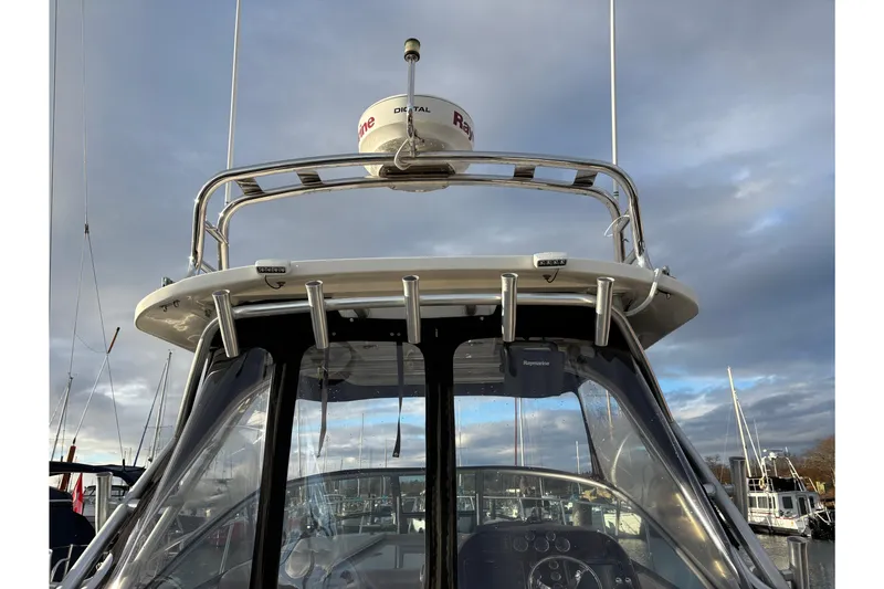 Slide: The Image of 2009 Sea Ray 290 Amberjack boat with radar and antenna, docked under cloudy skies. - 60
