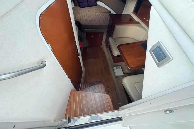 Slide: The Image of 2009 Sea Ray 290 Amberjack cabin interior with seating and wooden table. - 61