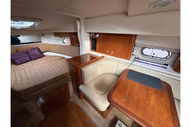 Slide: The Image of 2009 Sea Ray 290 Amberjack cabin interior with bed, seating, and wooden table. - 64