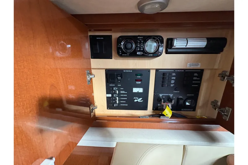Slide: The Image of 2009 Sea Ray 290 Amberjack control panel with audio system and electrical switches. - 79