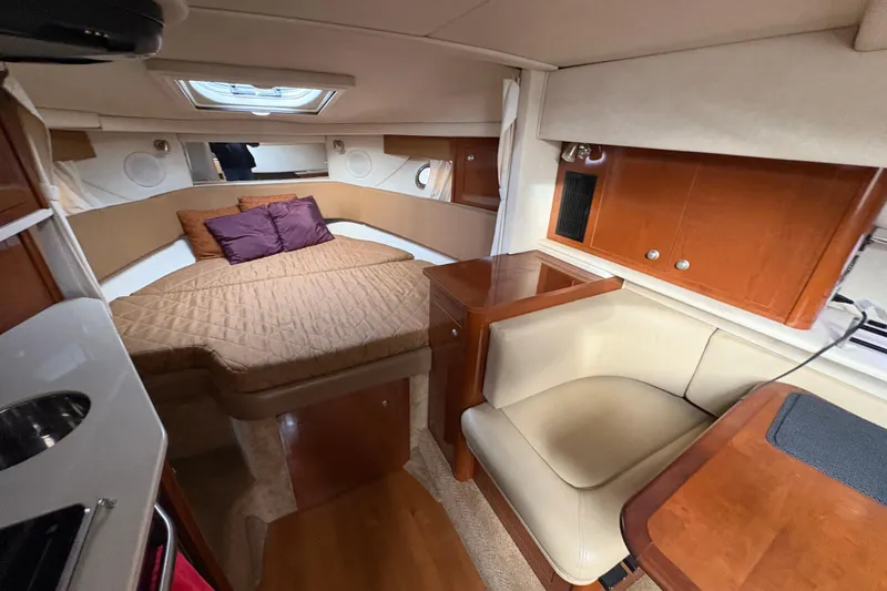 Slide: The Image of 2009 Sea Ray 290 Amberjack cabin interior with bed, seating, and wooden cabinetry. - 81