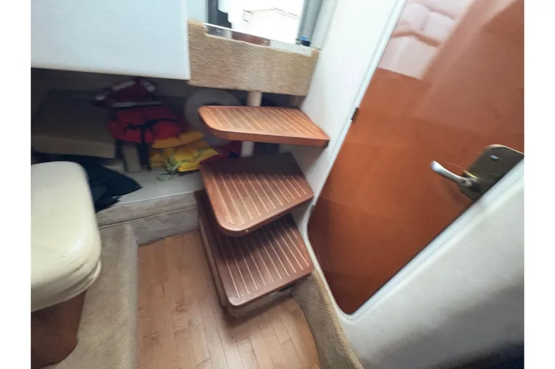 Slide: The Image of Interior of 2009 Sea Ray 290 Amberjack with wooden steps and life jackets. - 87