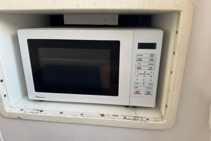 Slide: The Image of Built-in microwave on 2015 SeaHunter 41 Tournament boat, featuring digital controls and white finish. - 68