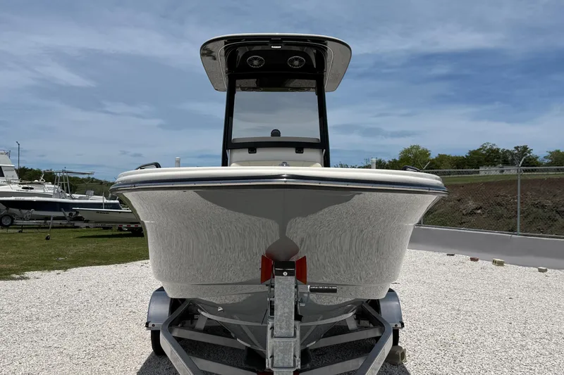 Slide: The Image of 2026 Scout 220 XSF boat on trailer, front view, outdoors under blue sky. - 11