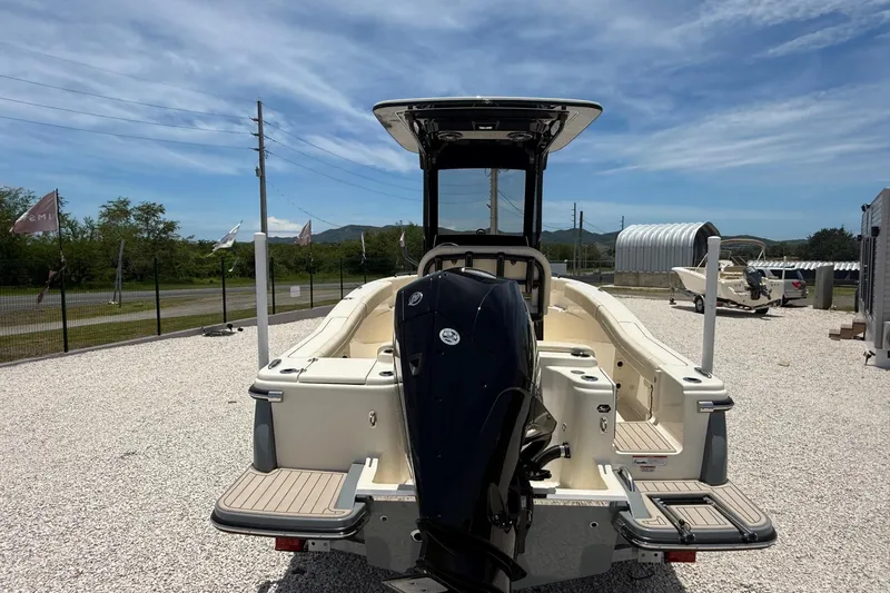 Slide: The Image of 2026 Scout 220 XSF boat with outboard motor, displayed outdoors on gravel. - 12