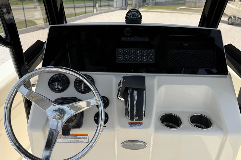 Slide: The Image of 2026 Scout 220 XSF boat dashboard with steering wheel, gauges, and controls. - 14