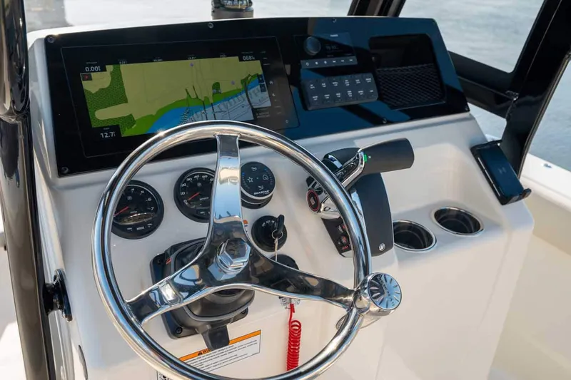 Slide: The Image of Manufacturer Provided Image: 2026 Scout 220 XSF boat dashboard with steering wheel and navigation display. - 2