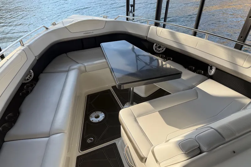 Slide: The Image of 2021 Formula 350 Crossover Bowrider I/O interior with seating and table, docked by water. - 15